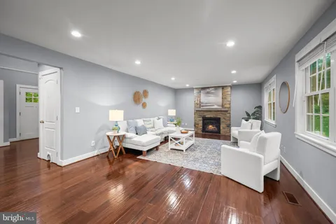 a kitchen with stainless steel appliances granite countertop a refrigerator a sink dishwasher a stove and white countertops with wooden floor