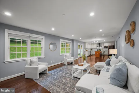 a kitchen with stainless steel appliances granite countertop a refrigerator a stove top oven a sink dishwasher and white cabinets with wooden floor