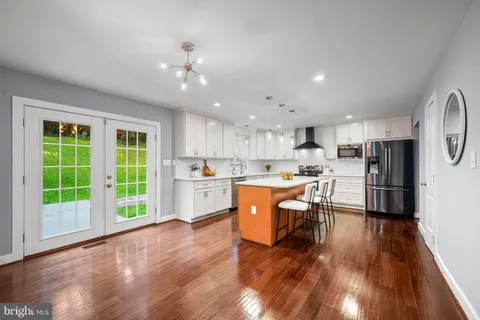 a kitchen with kitchen island wooden cabinets and white appliances