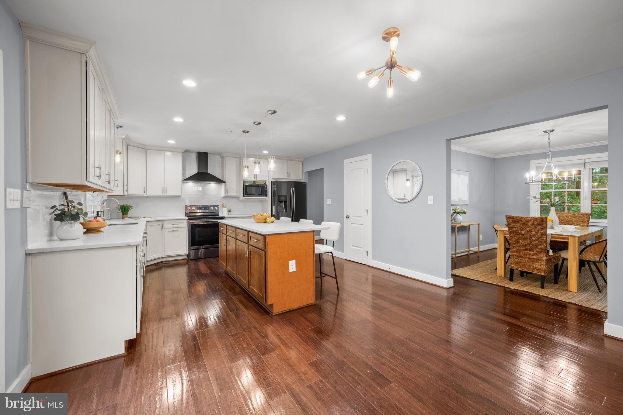 3319 Mail Road Westminster, MD 21157 - Photo 17 of 70 a large open kitchen with a refrigerator a stove a sink and a dining table with wooden floor