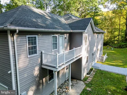a aerial view of a house with table and chairs in a yard