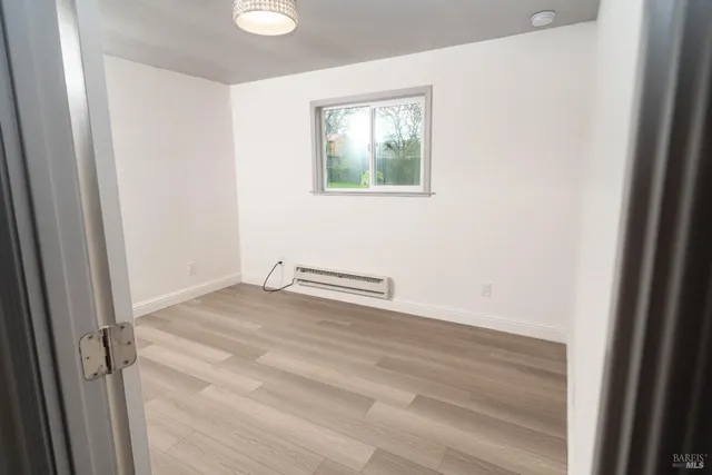 a view of a room with wooden floor and window