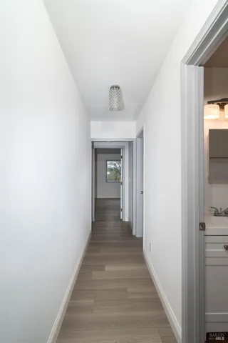 a view of a hallway with wooden floor and staircase