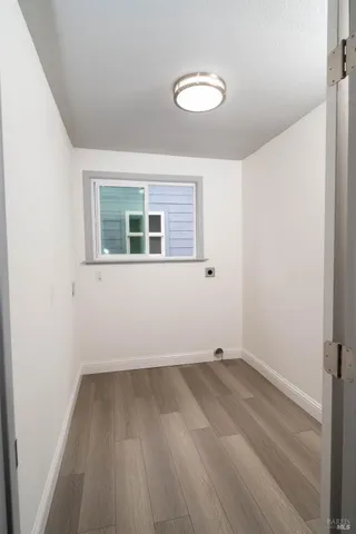 a view of a room with wooden floor and a window