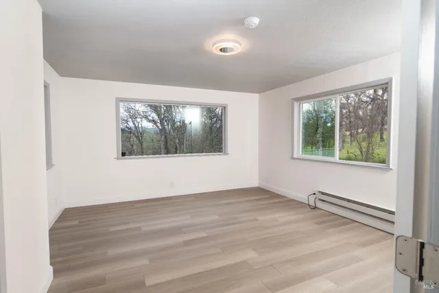 a view of an empty room with closet and a window