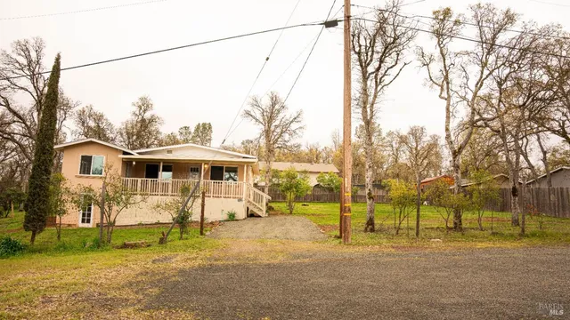 a front view of a house with a yard and trees