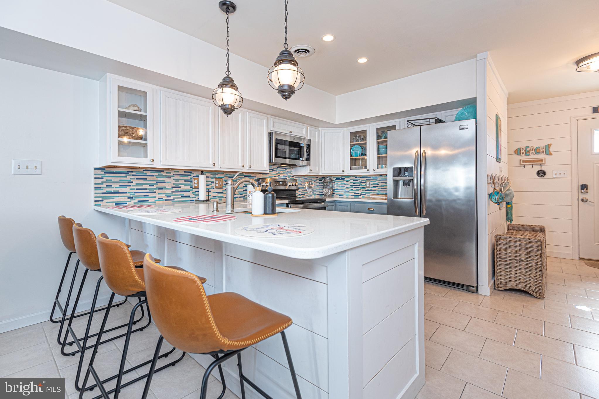 702 Bradley Road, Unit 11 Ocean City, MD 21842 - Photo 26 of 92 a kitchen with stainless steel appliances granite countertop a sink a stove a refrigerator and island