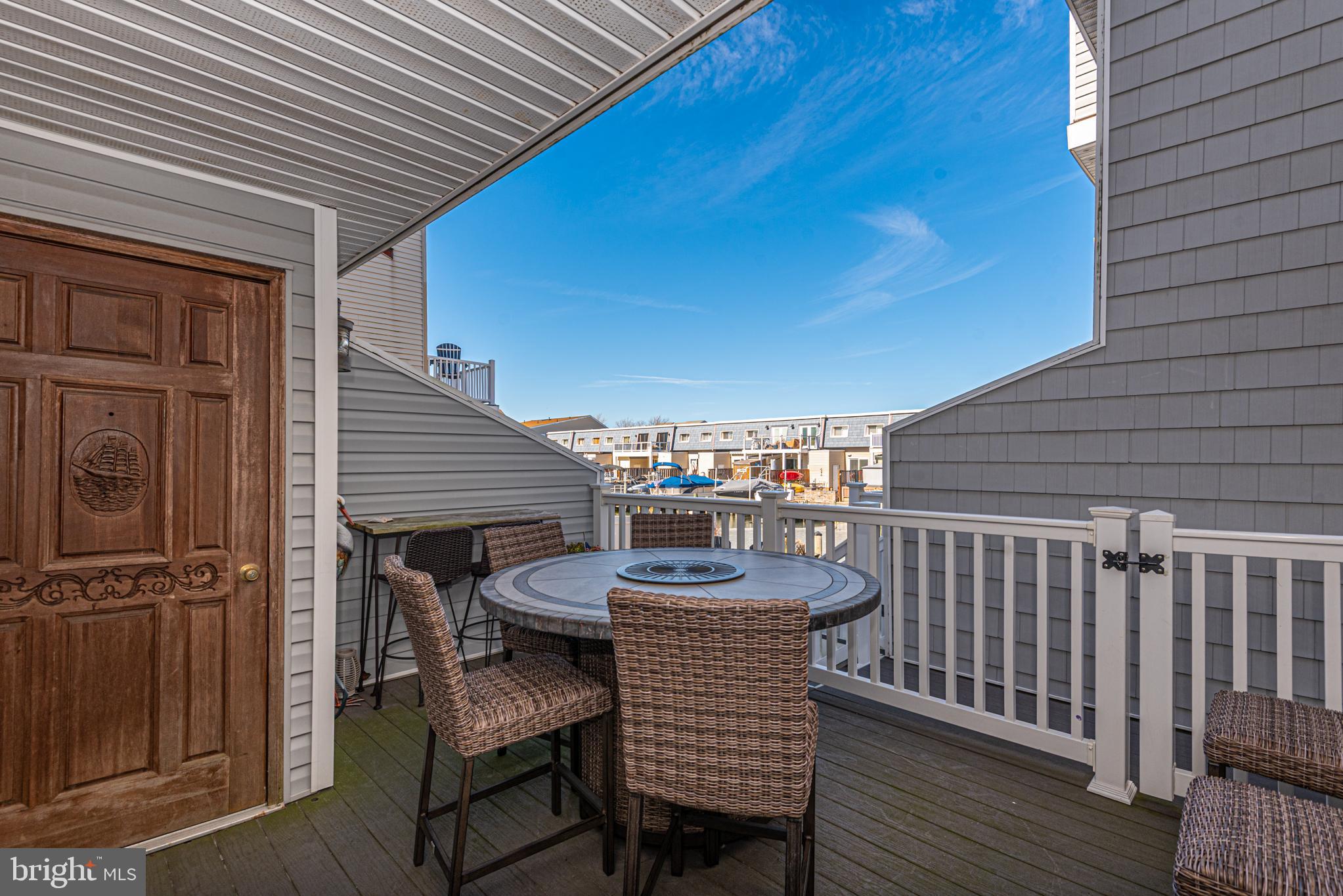702 Bradley Road, Unit 11 Ocean City, MD 21842 - Photo 33 of 92 a view of a patio with table and chairs with wooden floor and fence