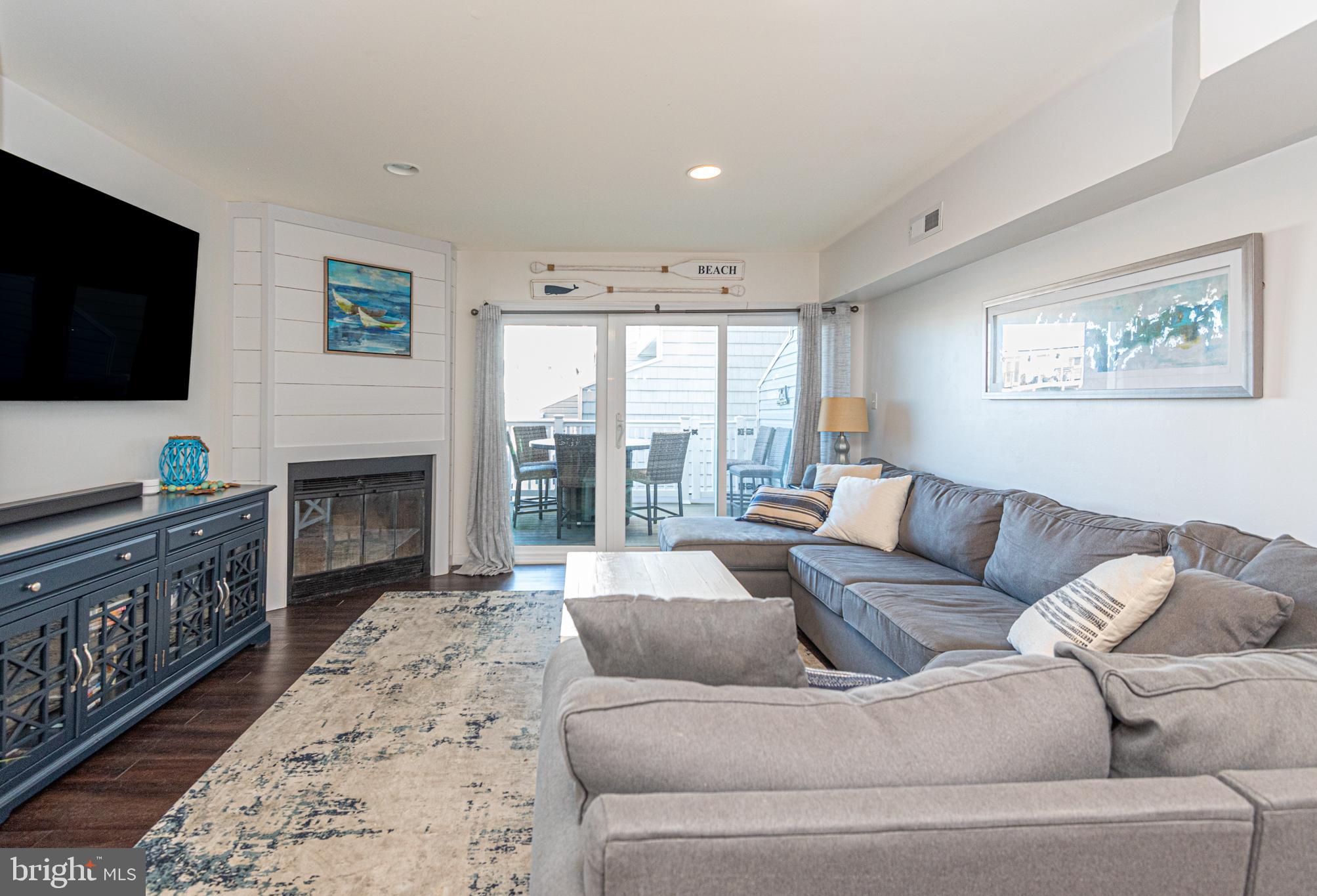 702 Bradley Road, Unit 11 Ocean City, MD 21842 - Photo 4 of 92 a living room with furniture a flat screen tv and a fireplace