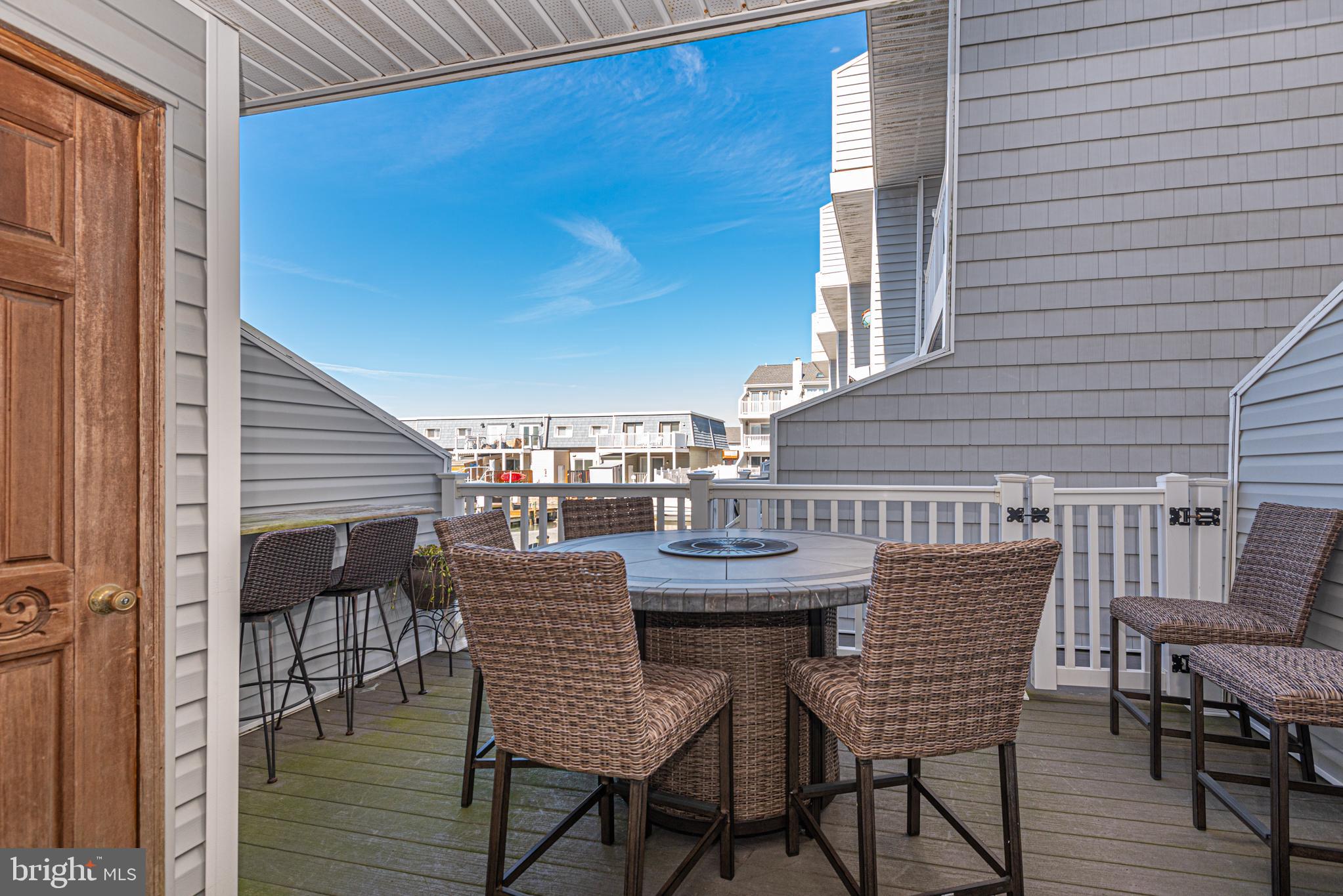 702 Bradley Road, Unit 11 Ocean City, MD 21842 - Photo 5 of 92 a view of a deck with table and chairs with wooden floor and stairs