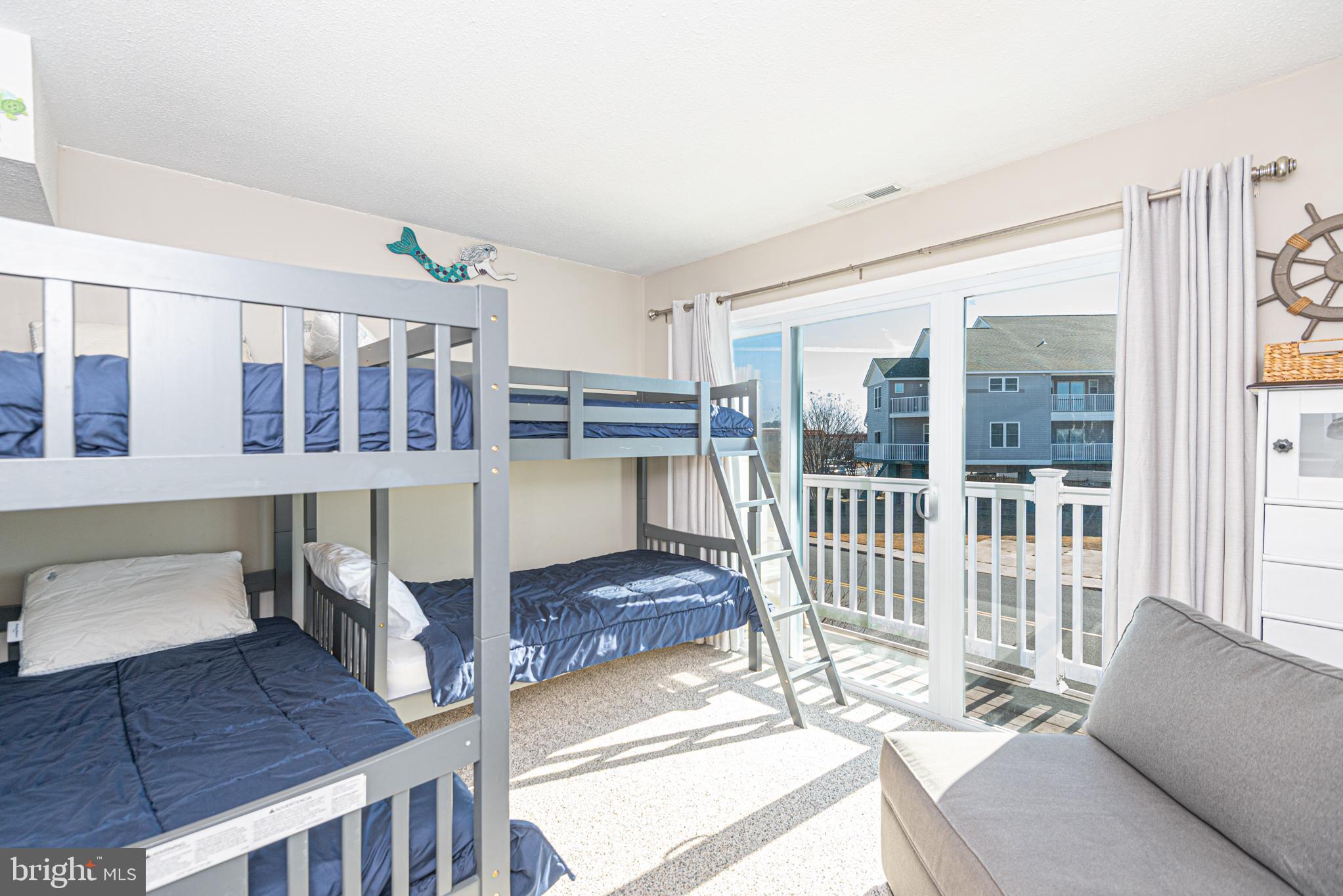 702 Bradley Road, Unit 11 Ocean City, MD 21842 - Photo 56 of 92 a living room with furniture a flat screen tv and windows