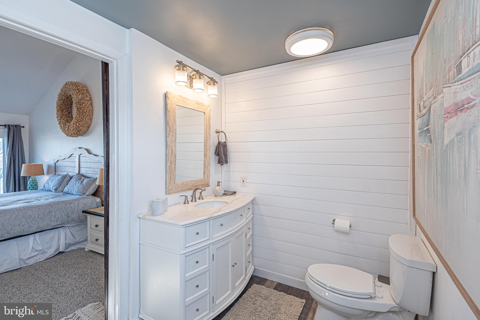 702 Bradley Road, Unit 11 Ocean City, MD 21842 - Photo 63 of 92 a bathroom with a toilet a sink a mirror a vanity and window