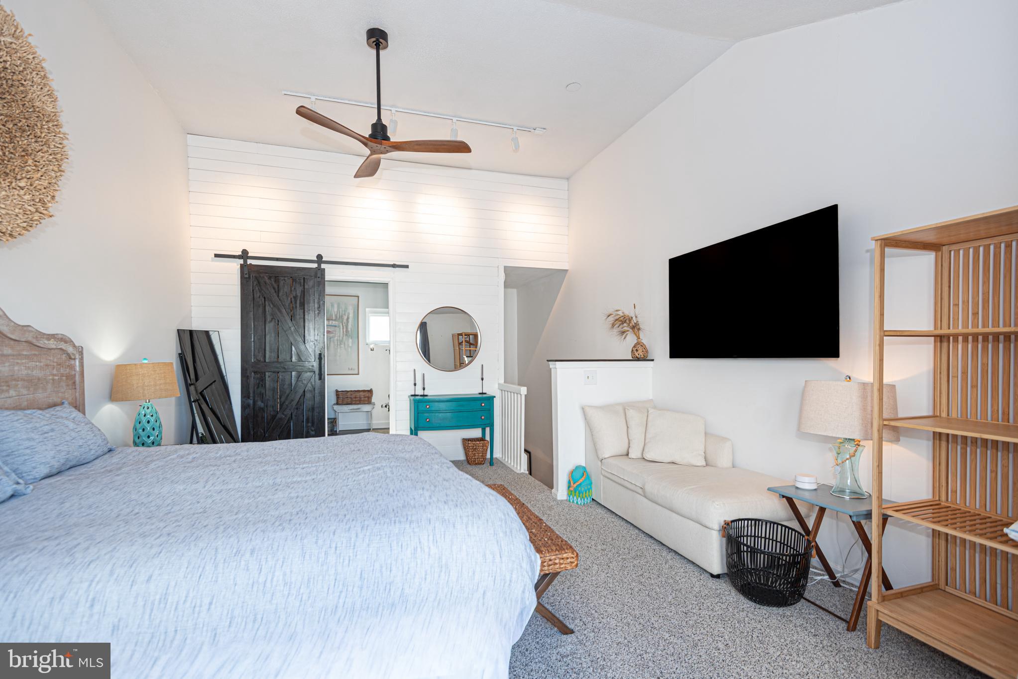 702 Bradley Road, Unit 11 Ocean City, MD 21842 - Photo 75 of 92 a bedroom with a bed a flat tv screen and a chandelier