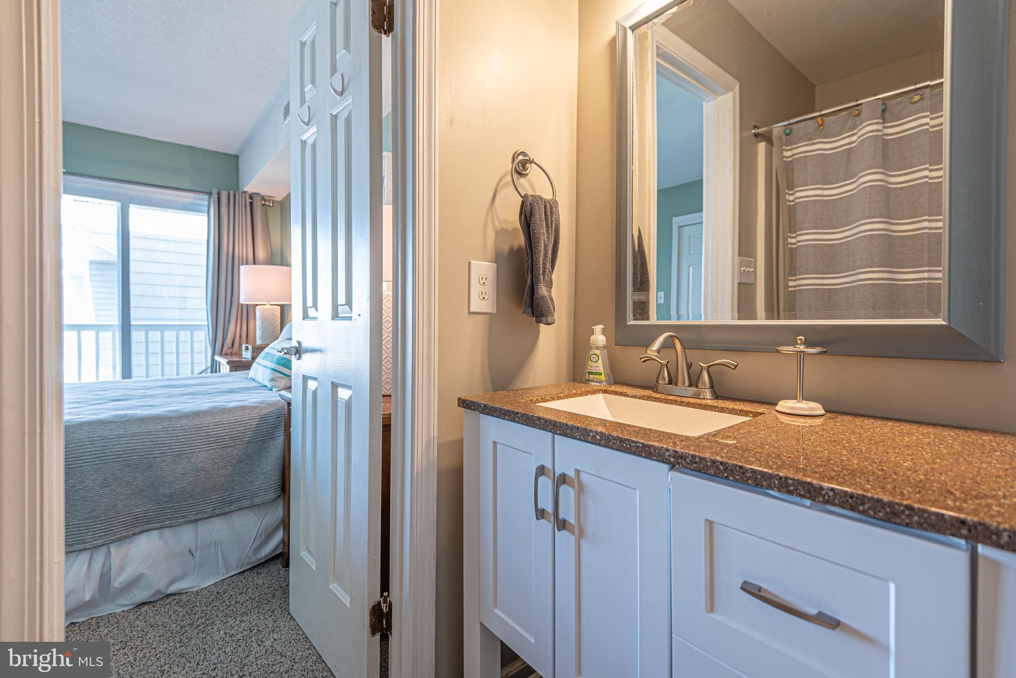 702 Bradley Road, Unit 11 Ocean City, MD 21842 - Photo 9 of 92 a en suite bathroom with a granite countertop sink and a mirror