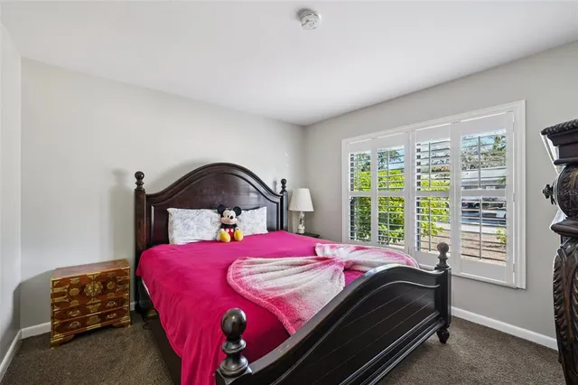 a bedroom with a bed a mirror and a window