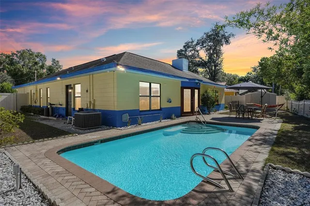 a view of a house with backyard swimming pool and sitting area