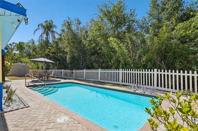 a view of a swimming pool with a patio and a yard