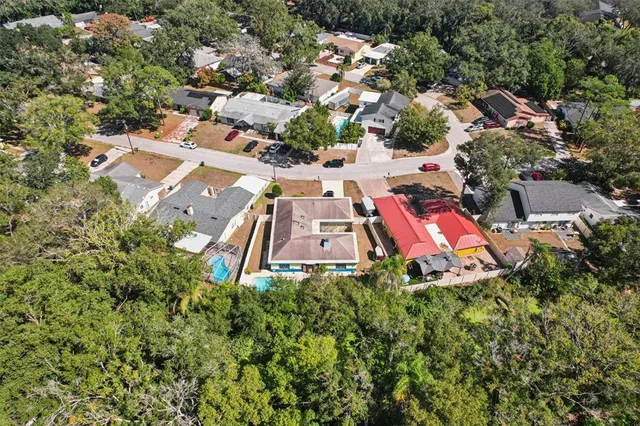 an aerial view of residential houses with outdoor space and trees