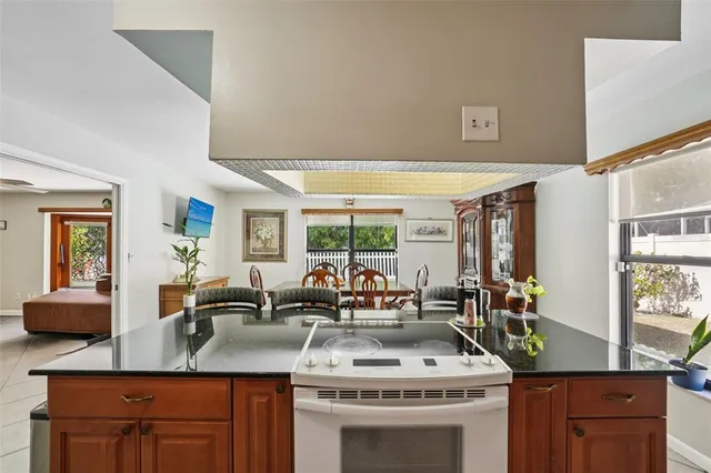a kitchen with stainless steel appliances granite countertop a sink a stove and a wooden cabinets