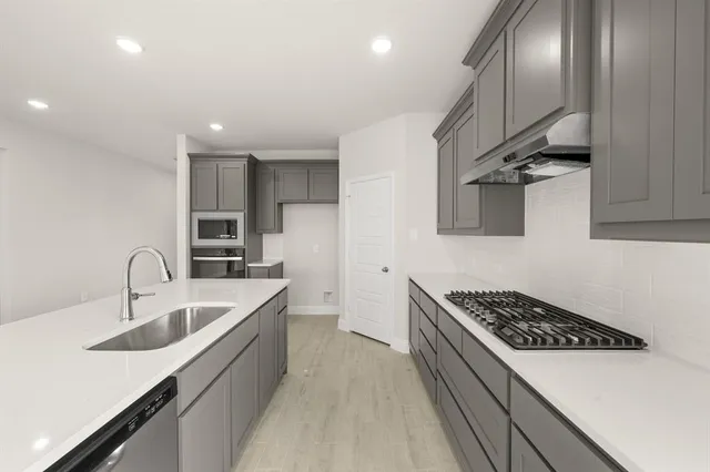 a kitchen with stainless steel appliances a sink stove and cabinets