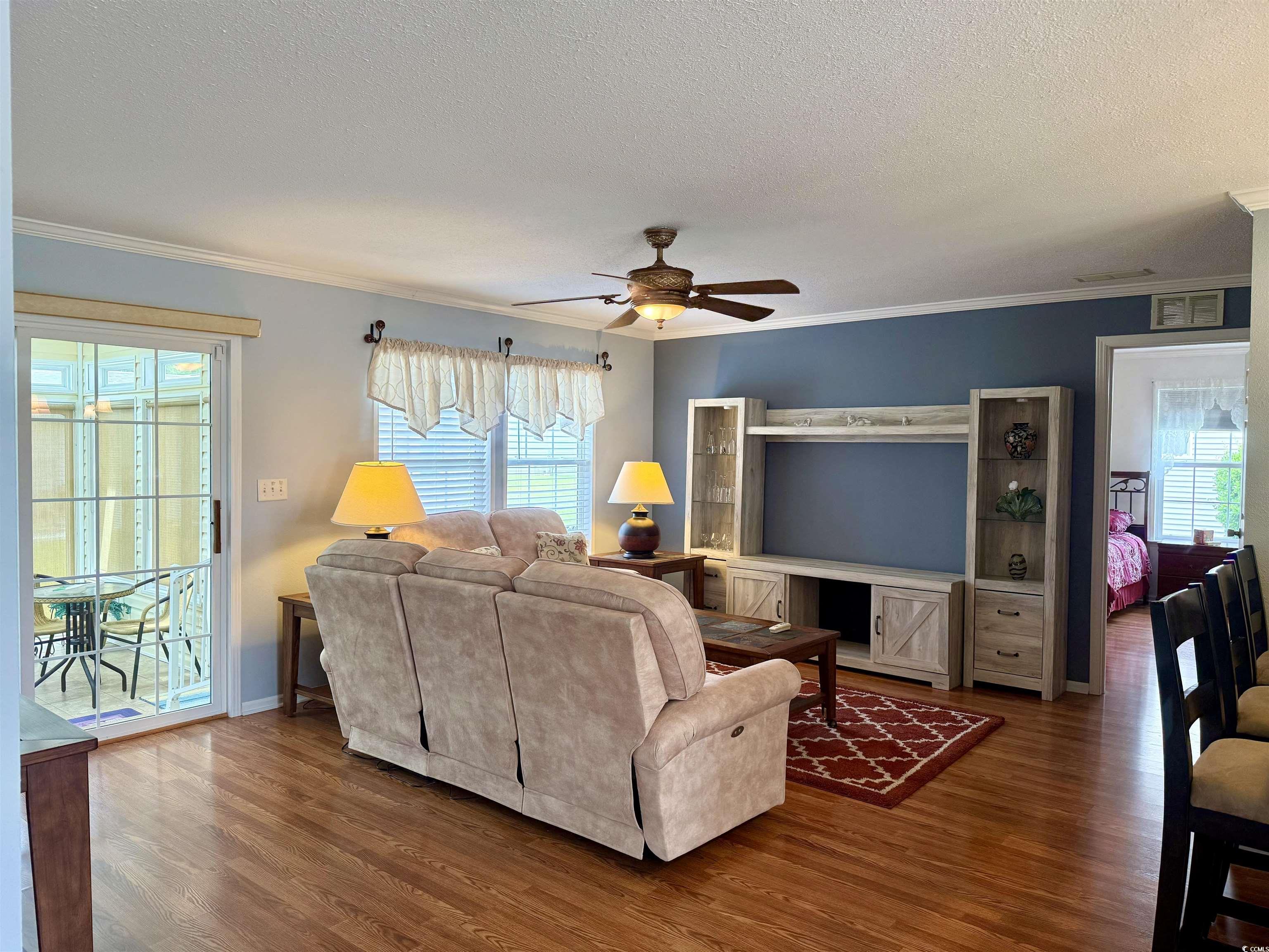216 Walden Lake Road Conway, SC 29526 - Photo 12 of 40 Living area featuring a ceiling fan, a textured ceiling, wood finished floors, and ornamental molding