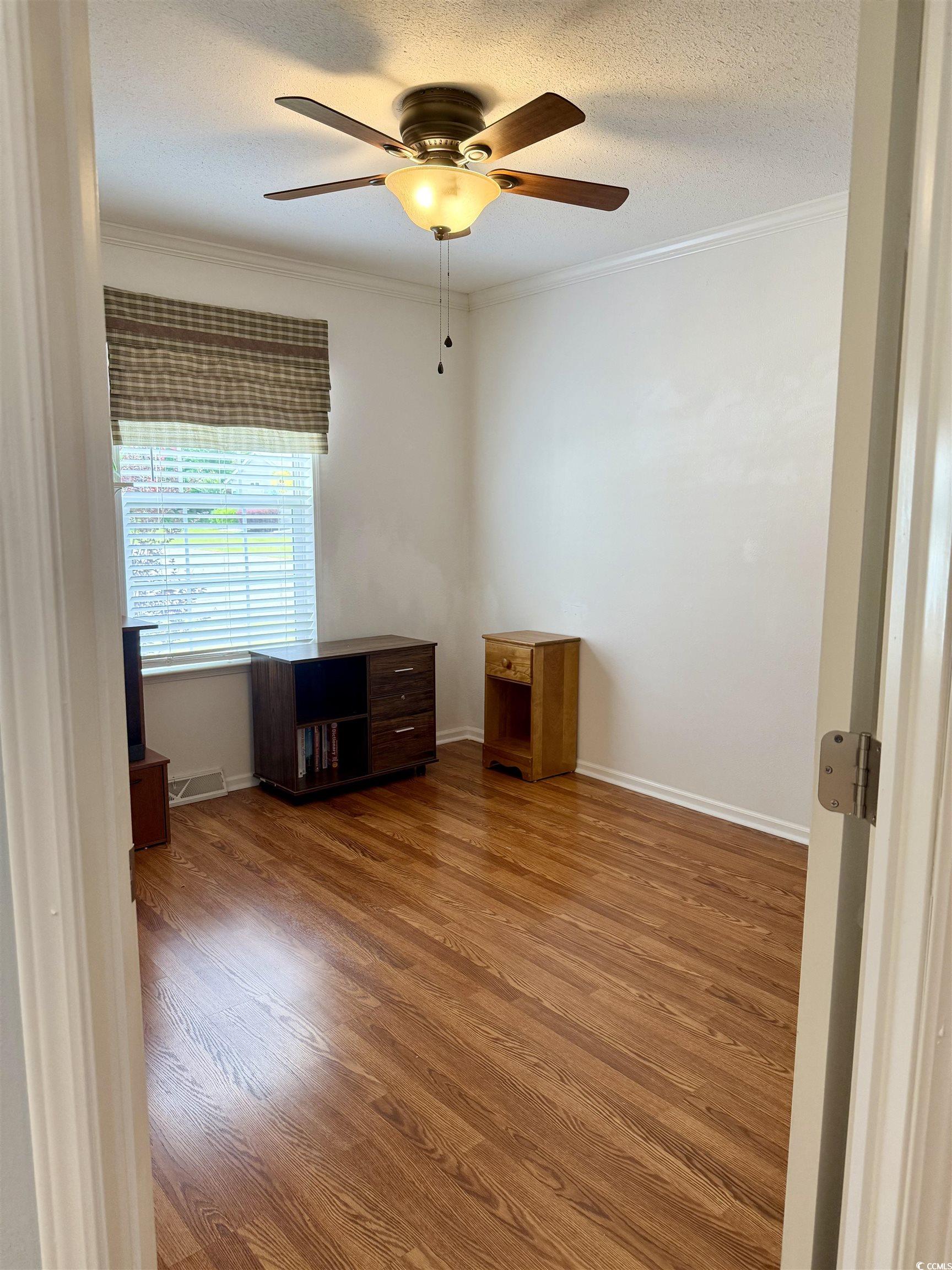 216 Walden Lake Road Conway, SC 29526 - Photo 21 of 40 Spare room with ceiling fan, crown molding, wood finished floors, a textured ceiling, and baseboards