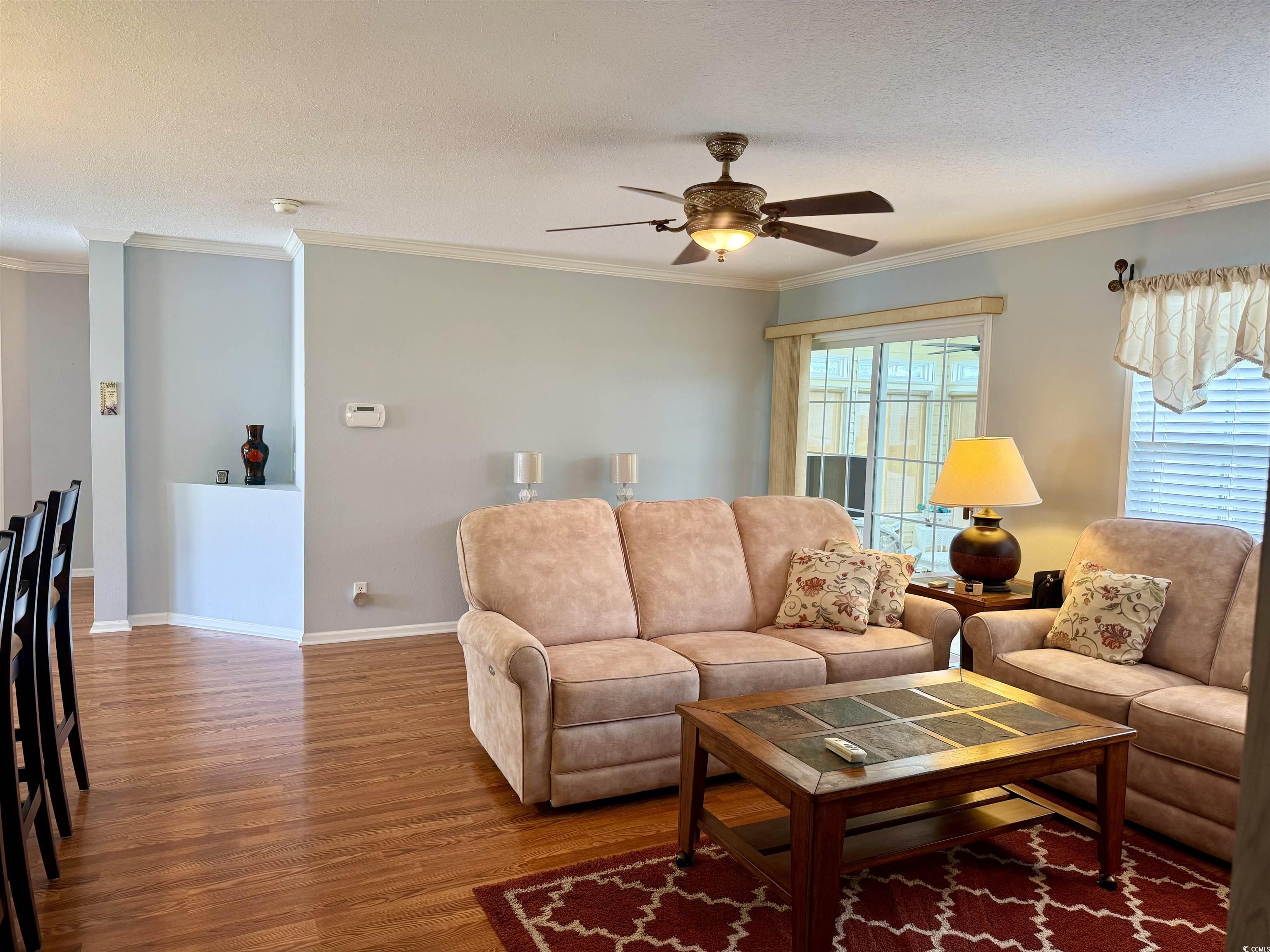 216 Walden Lake Road Conway, SC 29526 - Photo 25 of 40 Living area with wood finished floors, ornamental molding, a ceiling fan, baseboards, and a textured ceiling