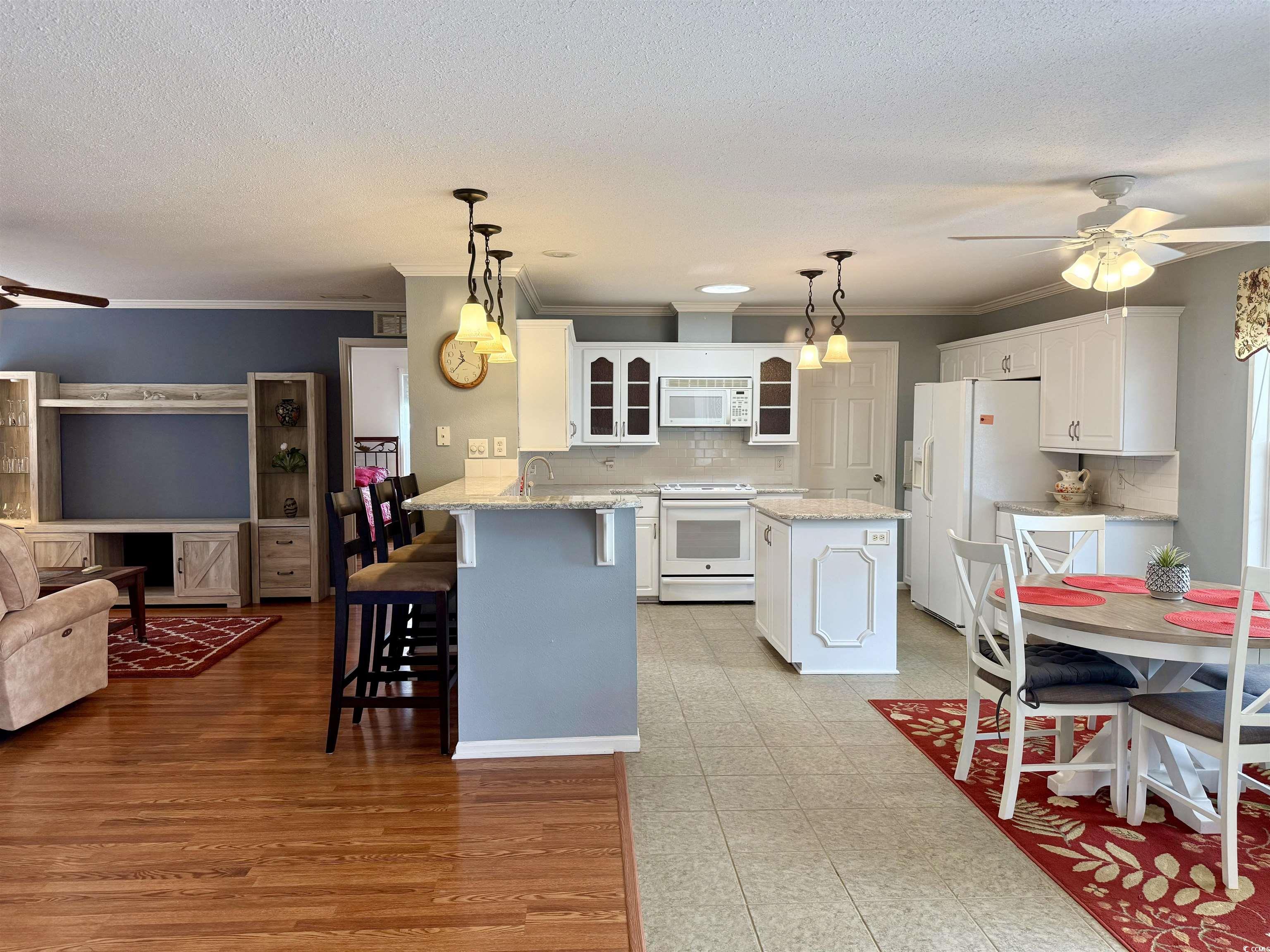 216 Walden Lake Road Conway, SC 29526 - Photo 6 of 40 Kitchen with white appliances, ceiling fan, a peninsula, glass insert cabinets, and crown molding