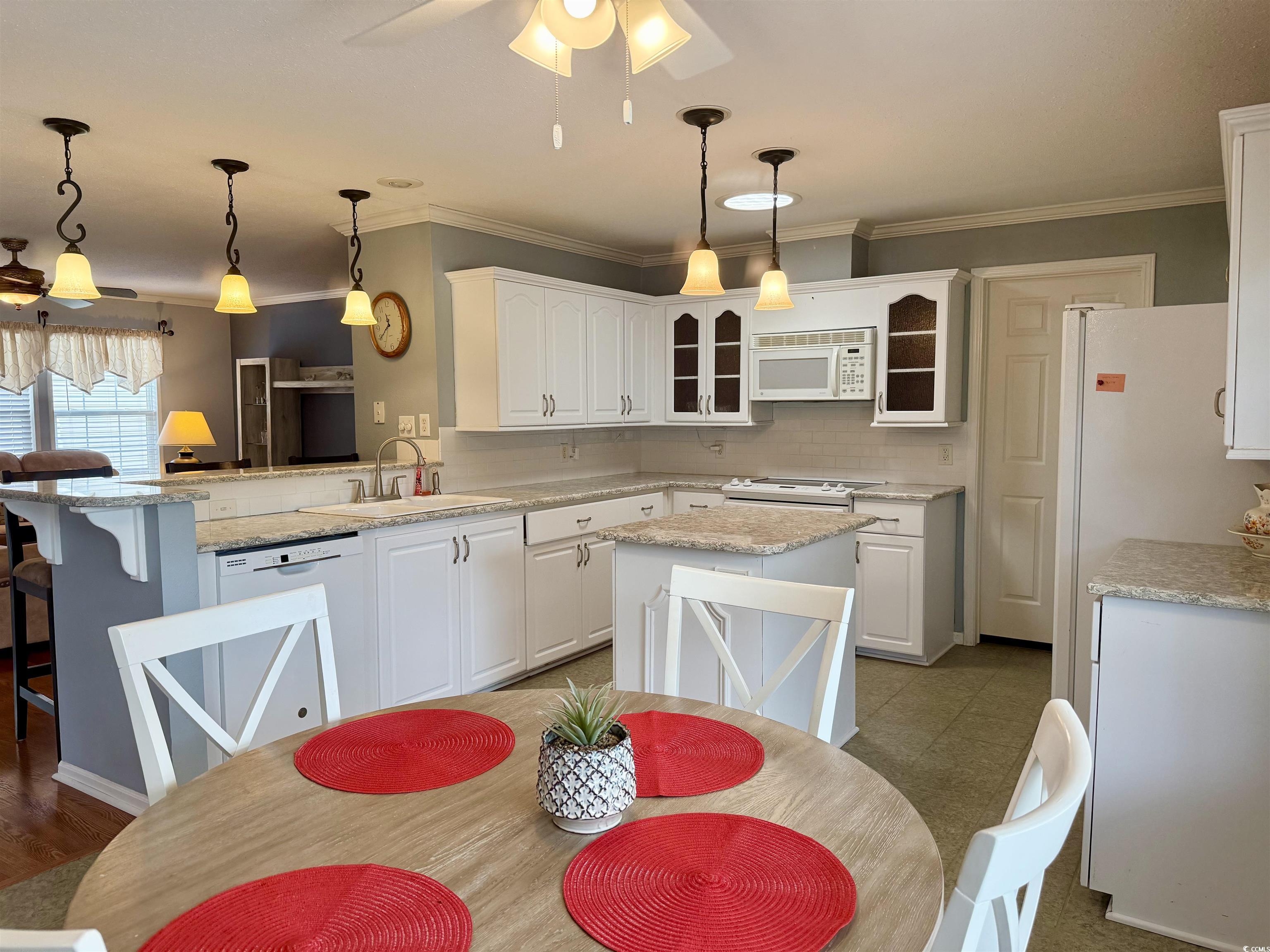 216 Walden Lake Road Conway, SC 29526 - Photo 9 of 40 Kitchen featuring white appliances, a sink, glass insert cabinets, a peninsula, and ornamental molding