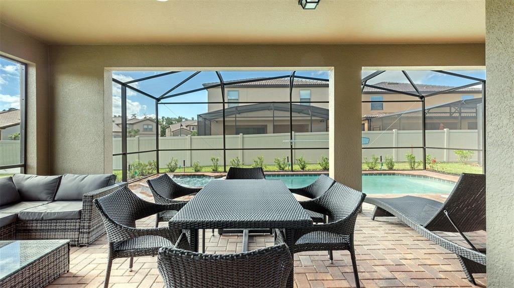 8894 Qin Loop Davenport, FL 33896 - Photo 27 of 47 a view of a living room and a table and chairs in patio