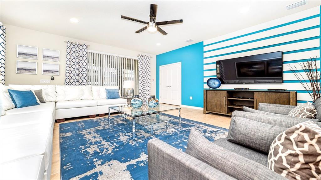 8894 Qin Loop Davenport, FL 33896 - Photo 8 of 47 a living room with furniture and a flat screen tv