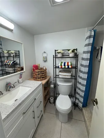 a bathroom with a granite countertop toilet sink and mirror