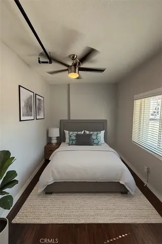 a bedroom with a bed and a ceiling fan