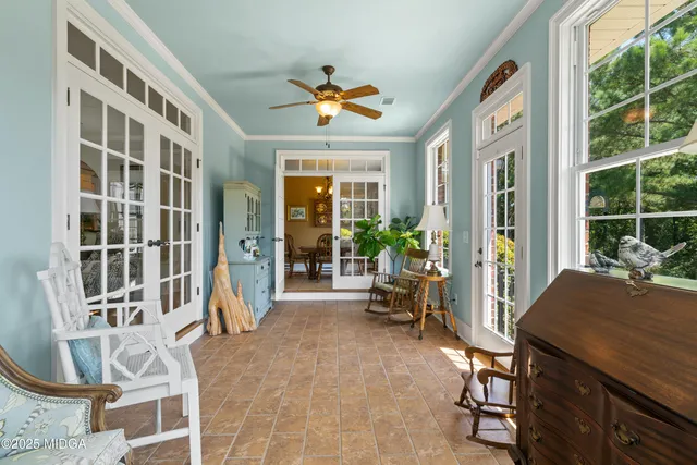 a bedroom with a bed a chandelier with a flat tv screen and dresser