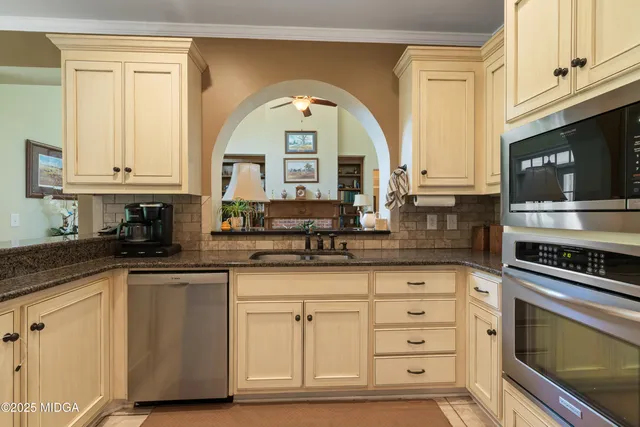 a kitchen with stainless steel appliances granite countertop a stove a sink and a microwave
