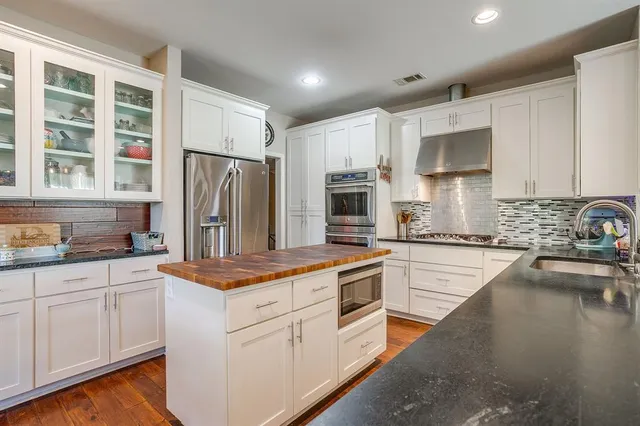 a kitchen with white cabinets and stainless steel appliances