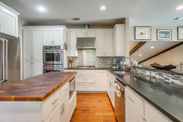 a kitchen with stainless steel appliances granite countertop a sink and cabinets
