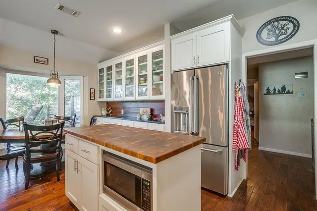 a kitchen with a stove a refrigerator and a table