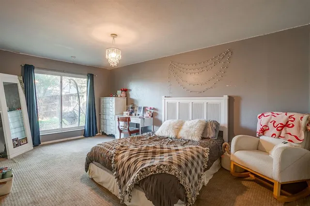 a spacious bedroom with a bed a couch and a window