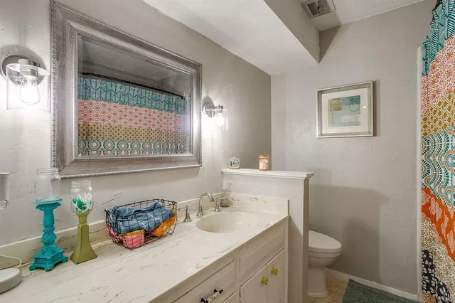 a bathroom with a sink a toilet and a mirror