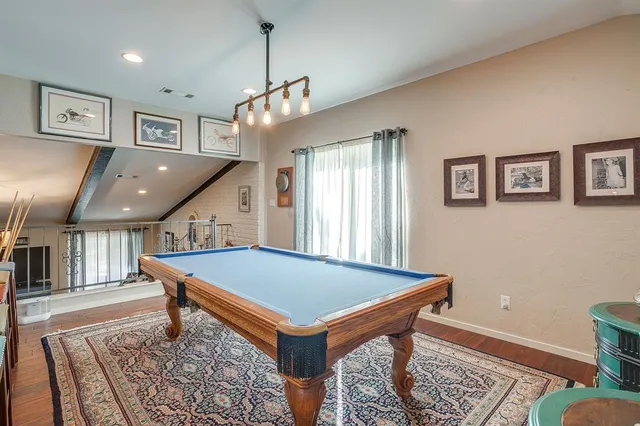 a room with pool table and windows