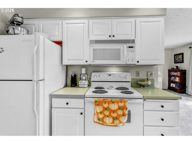 a kitchen with stainless steel appliances granite countertop a refrigerator sink stove and white cabinets