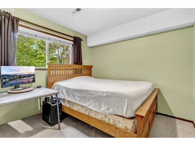 a bedroom with a bed and a large window