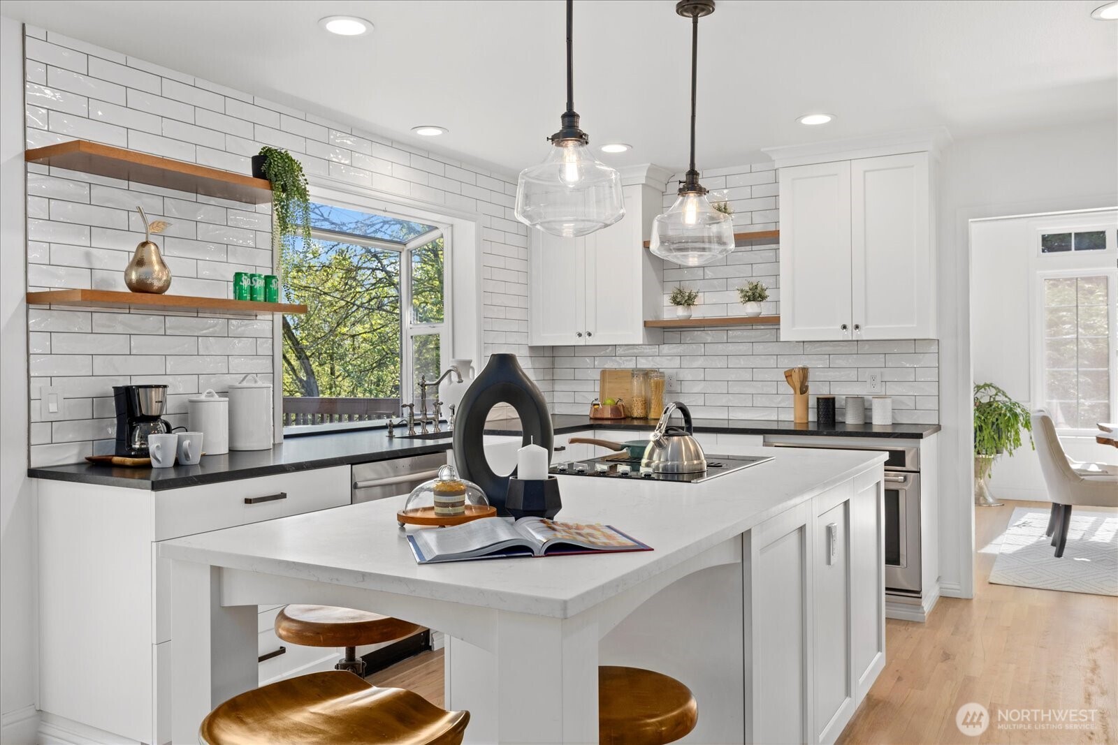 10906 Northeast 197th Street Bothell, WA 98011 - Photo 11 of 38 a kitchen with a stove a sink a kitchen island a stove and a window with wooden floor