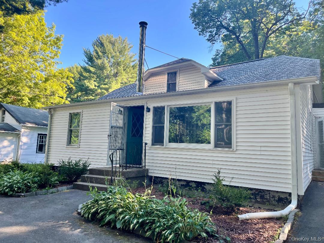 View of front facade featuring a shingled roof