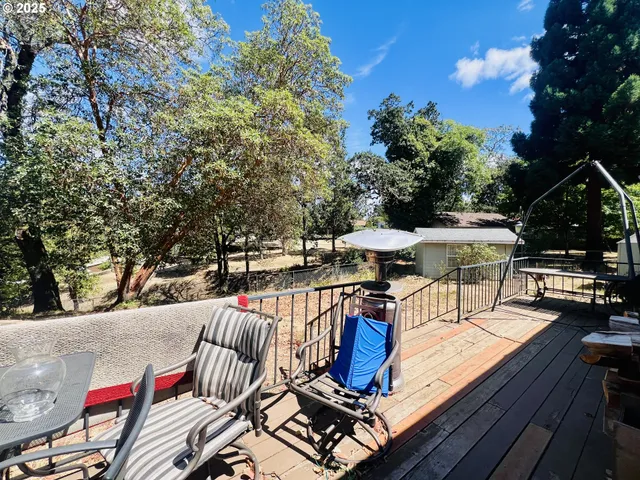 a view of a patio with table and chairs potted plants with wooden floor and fence