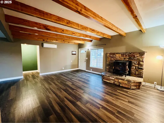 a view of a livingroom with wooden floor and a fireplace