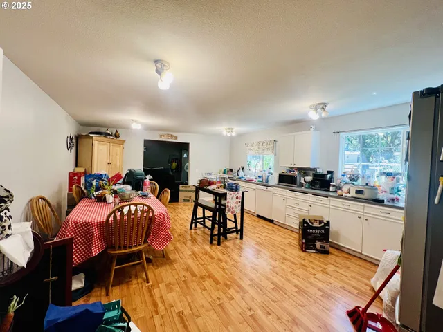 a large living room with stainless steel appliances kitchen island granite countertop furniture and a kitchen view