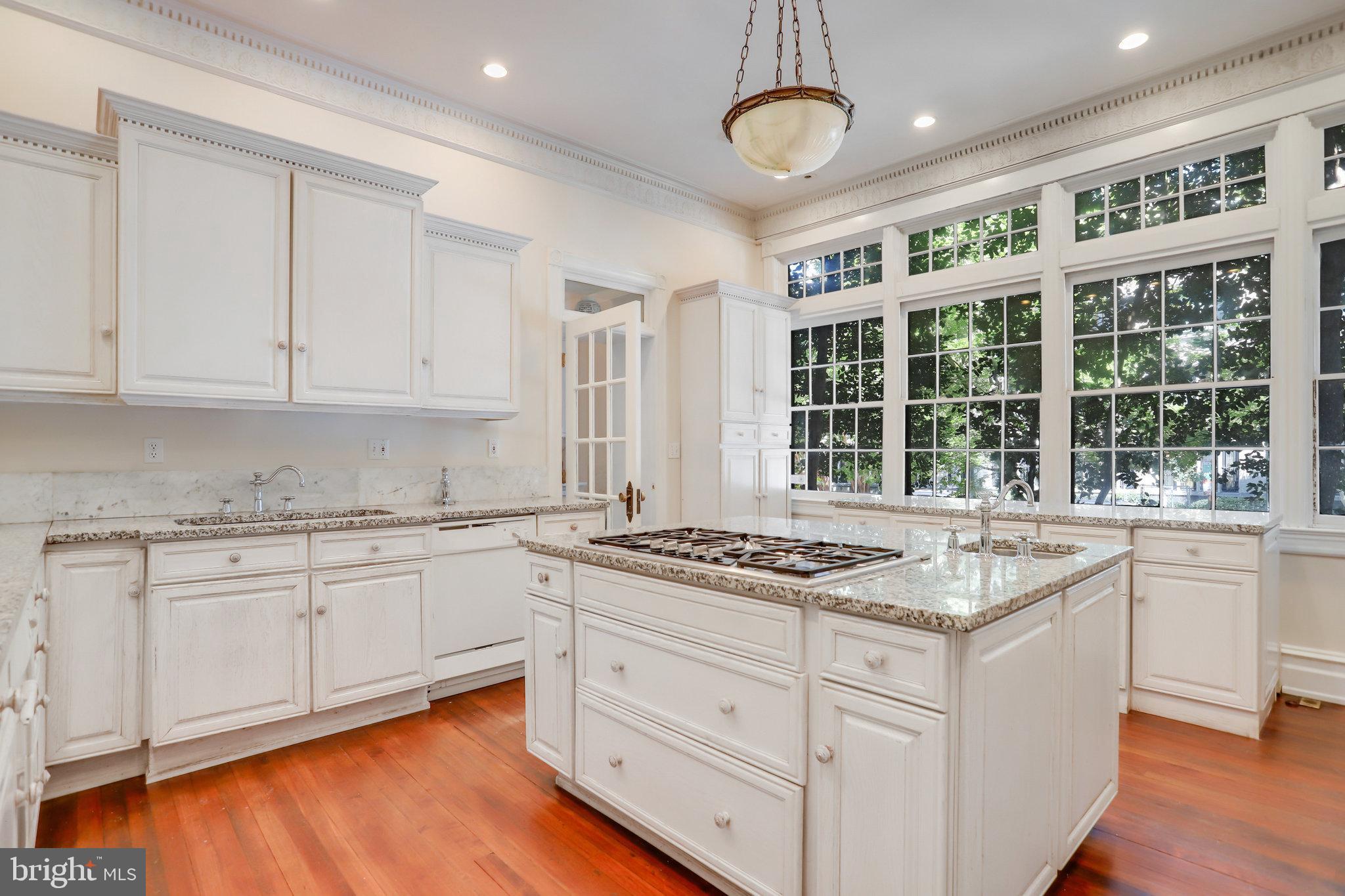 1633 16th Street Northwest Washington, DC 20009 - Photo 33 of 130 a kitchen with stainless steel appliances granite countertop a stove a sink and white cabinets with wooden floor