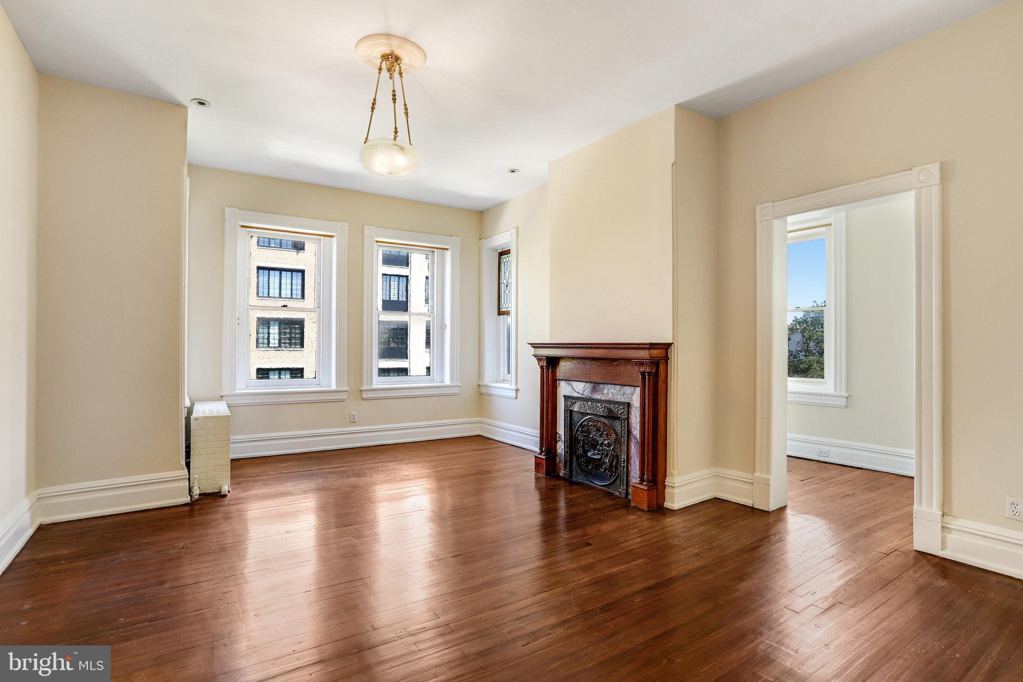 1633 16th Street Northwest Washington, DC 20009 - Photo 75 of 130 an empty room with wooden floor fireplace and windows